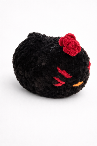 Black plush toy with red accents on a white background