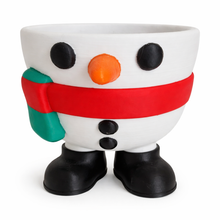 Snowman-shaped planter with a red scarf, black buttons, and an orange nose on a white background