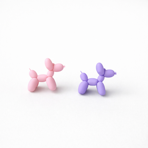 Pink and purple balloon dog earrings on a white background