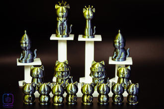 Collection of metallic cat figurines on a dark background