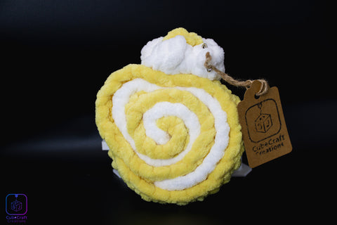 Yellow and white spiral fabric toy with a brown tag on a black background