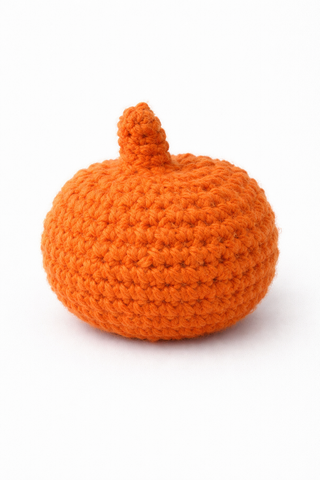 Knitted orange pumpkin on a white background