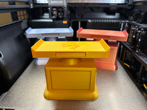 3D printed trophies in various colors on a 3D printer bed.