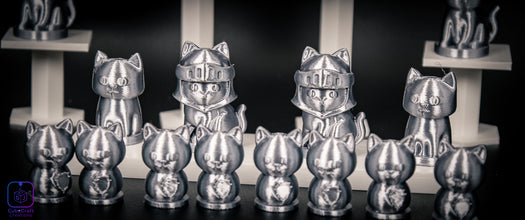 Collection of silver cat figurines with various poses on a dark background