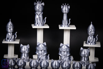 Metallic cat figurines with various poses on stands against a black background
